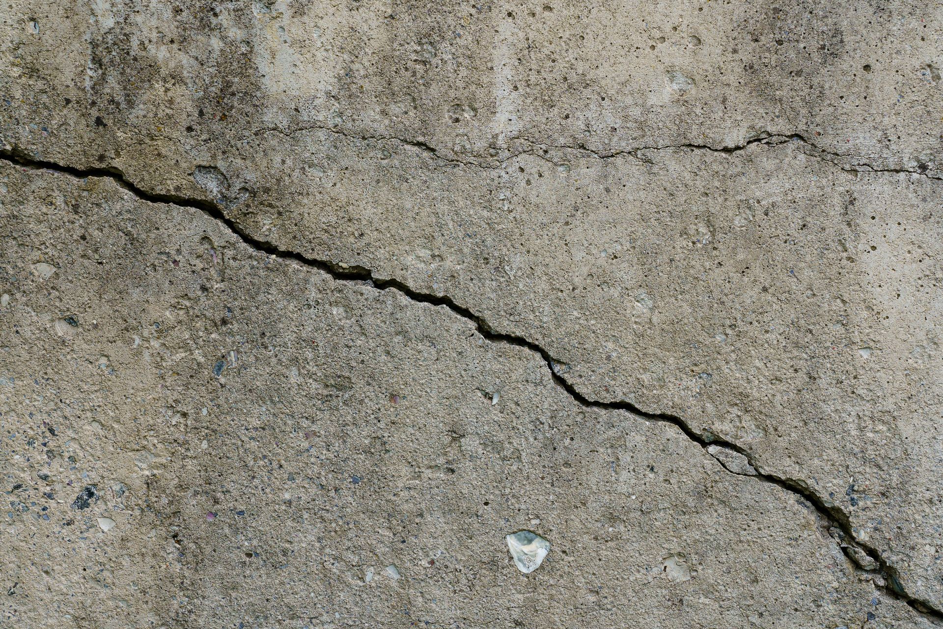 Cracked concrete slab. Wall made of cement with crack. House foundation repair. Texture surface 