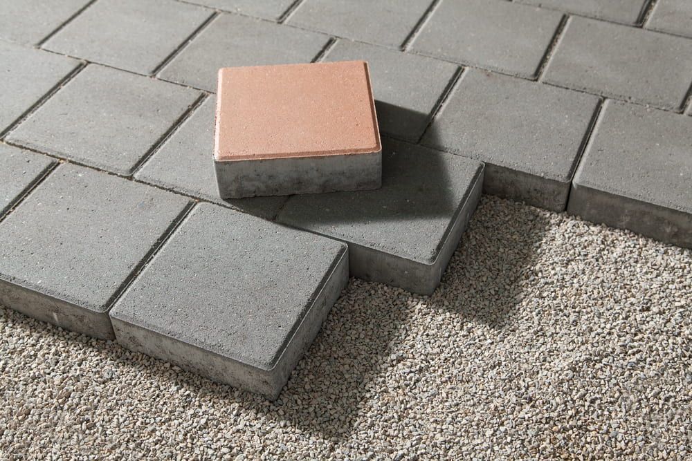 A Brick Is Sitting On Top Of A Brick Pavement — Mid Coast Tiles Urunga In Urunga, NSW