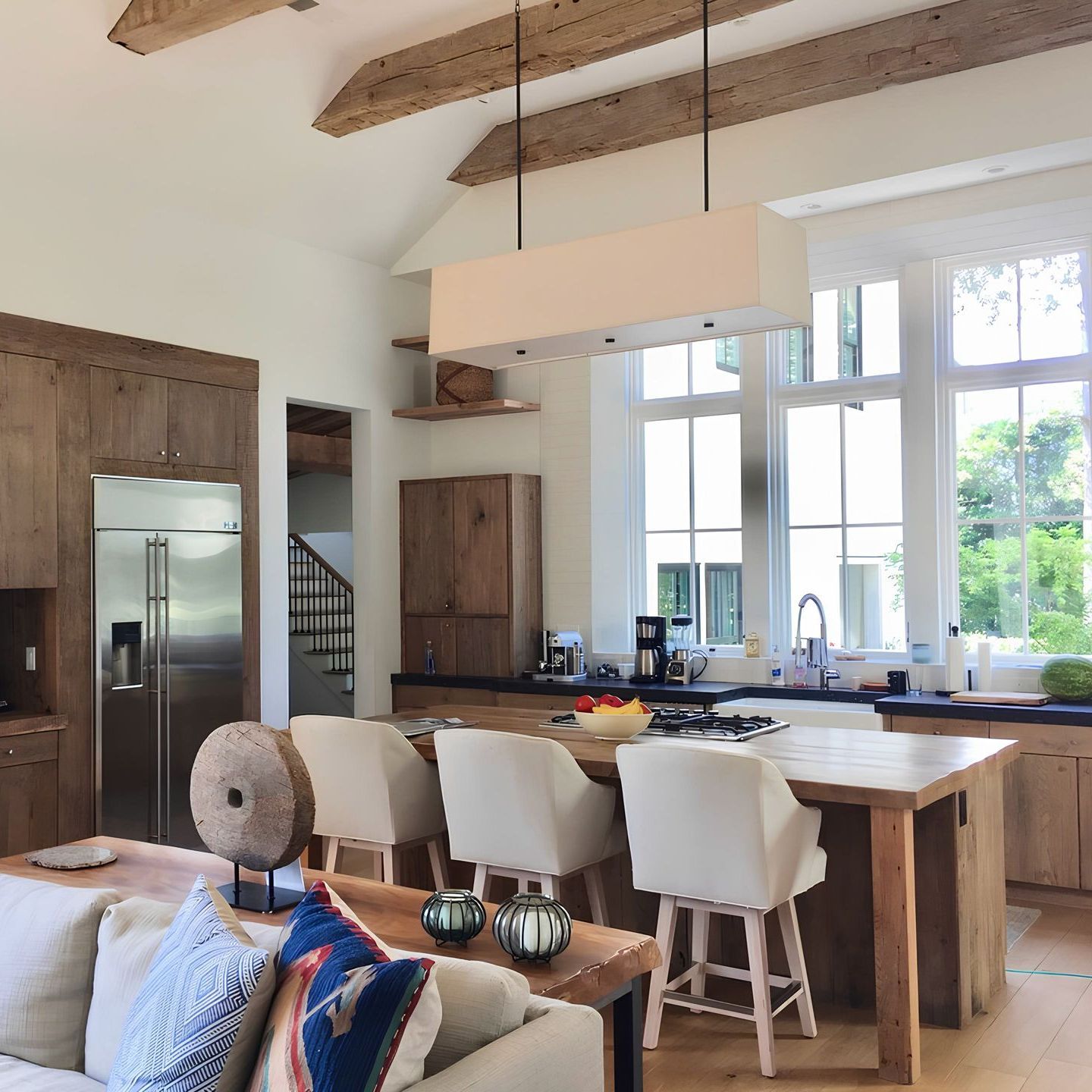 A living room with a couch and chairs and a kitchen