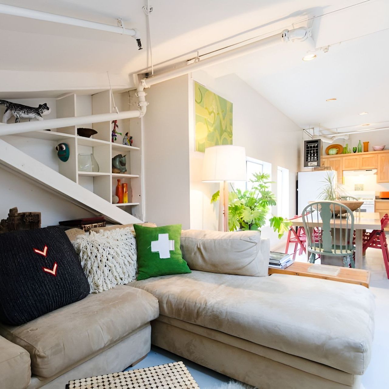 A living room with a couch and a green cross pillow