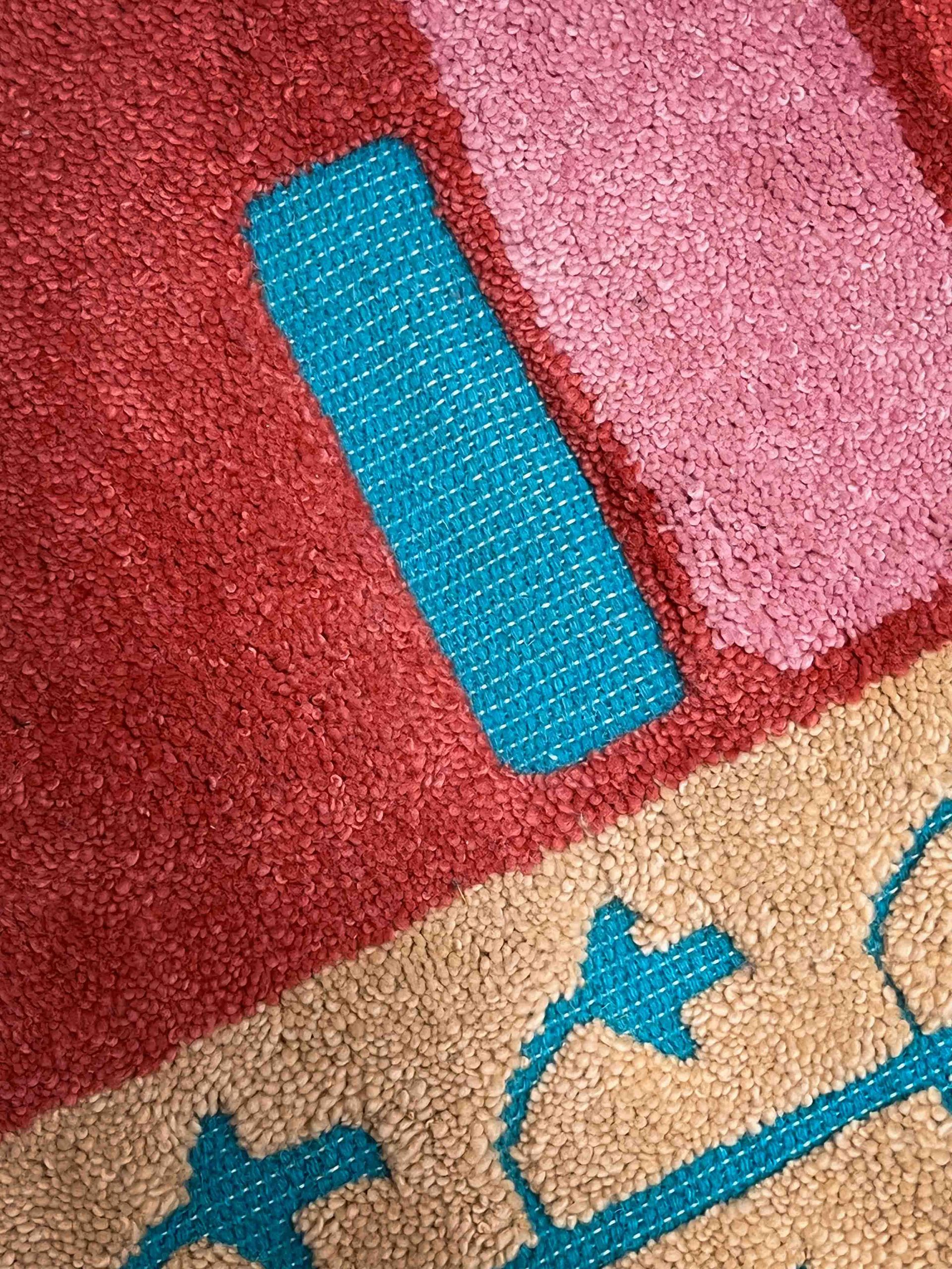 A close up of a rug with a blue stripe on it.