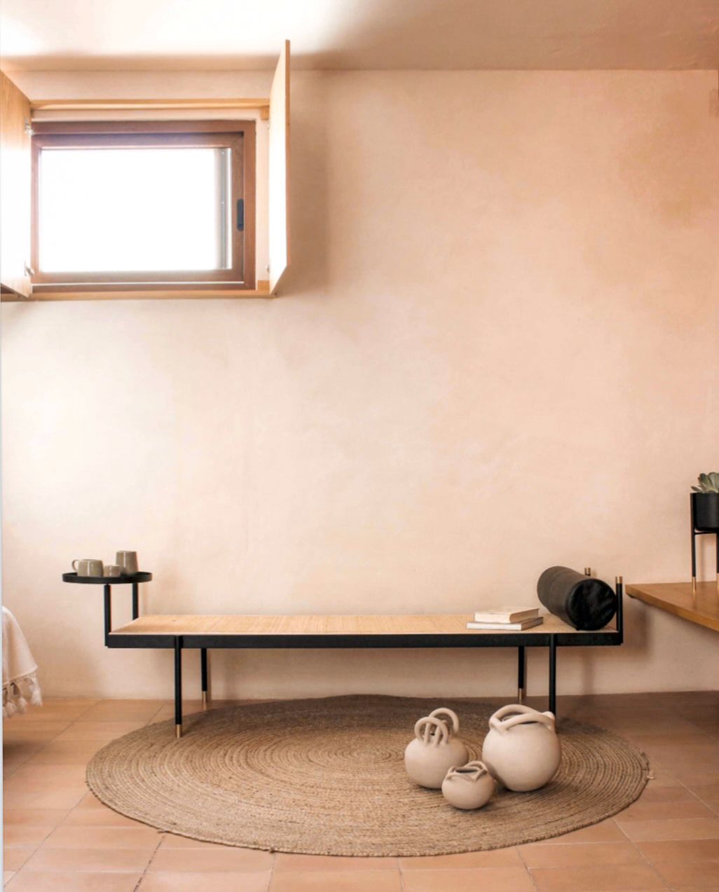 A room with a bench and a round rug on the floor