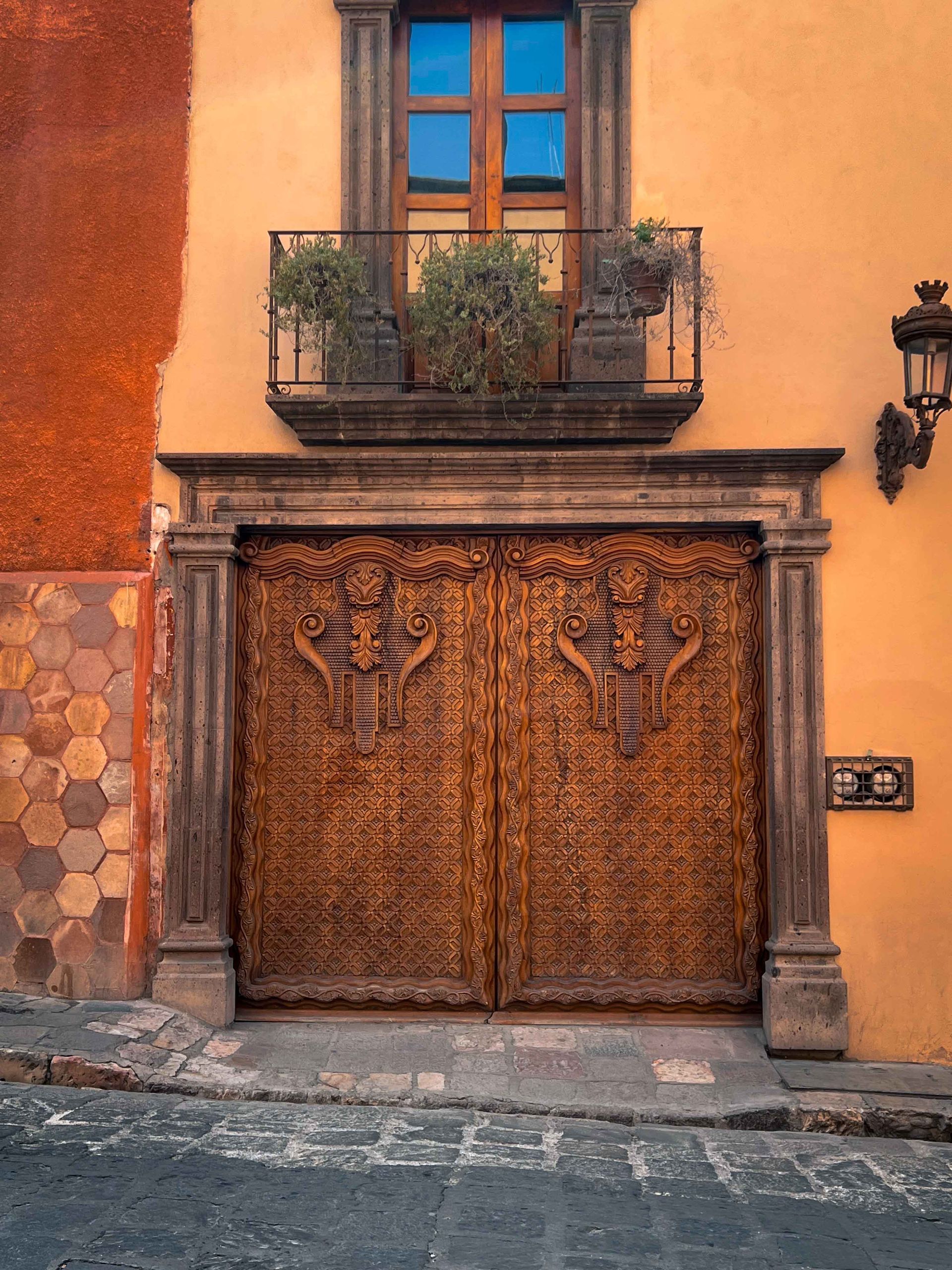 A yellow building with a balcony and a wooden door