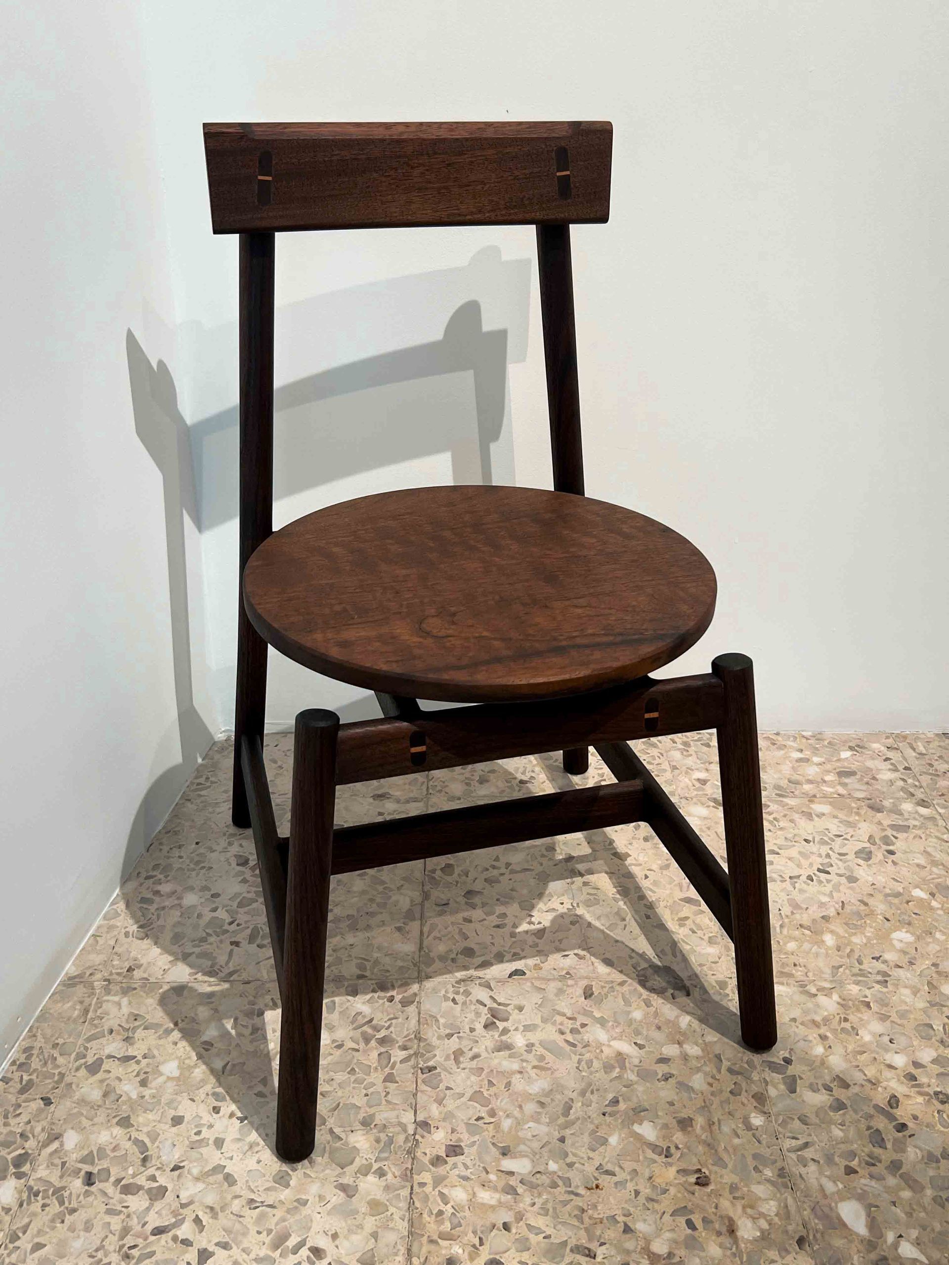 A wooden chair is sitting in a corner of a room