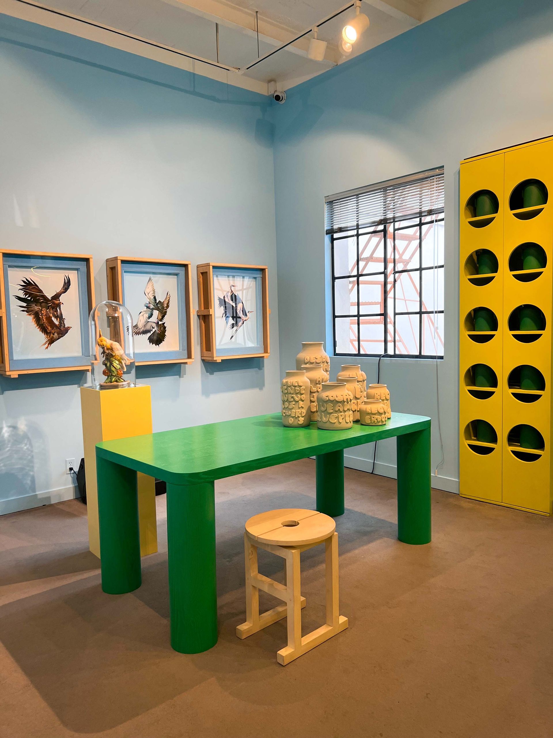 A showroom with a green table and a yellow wall