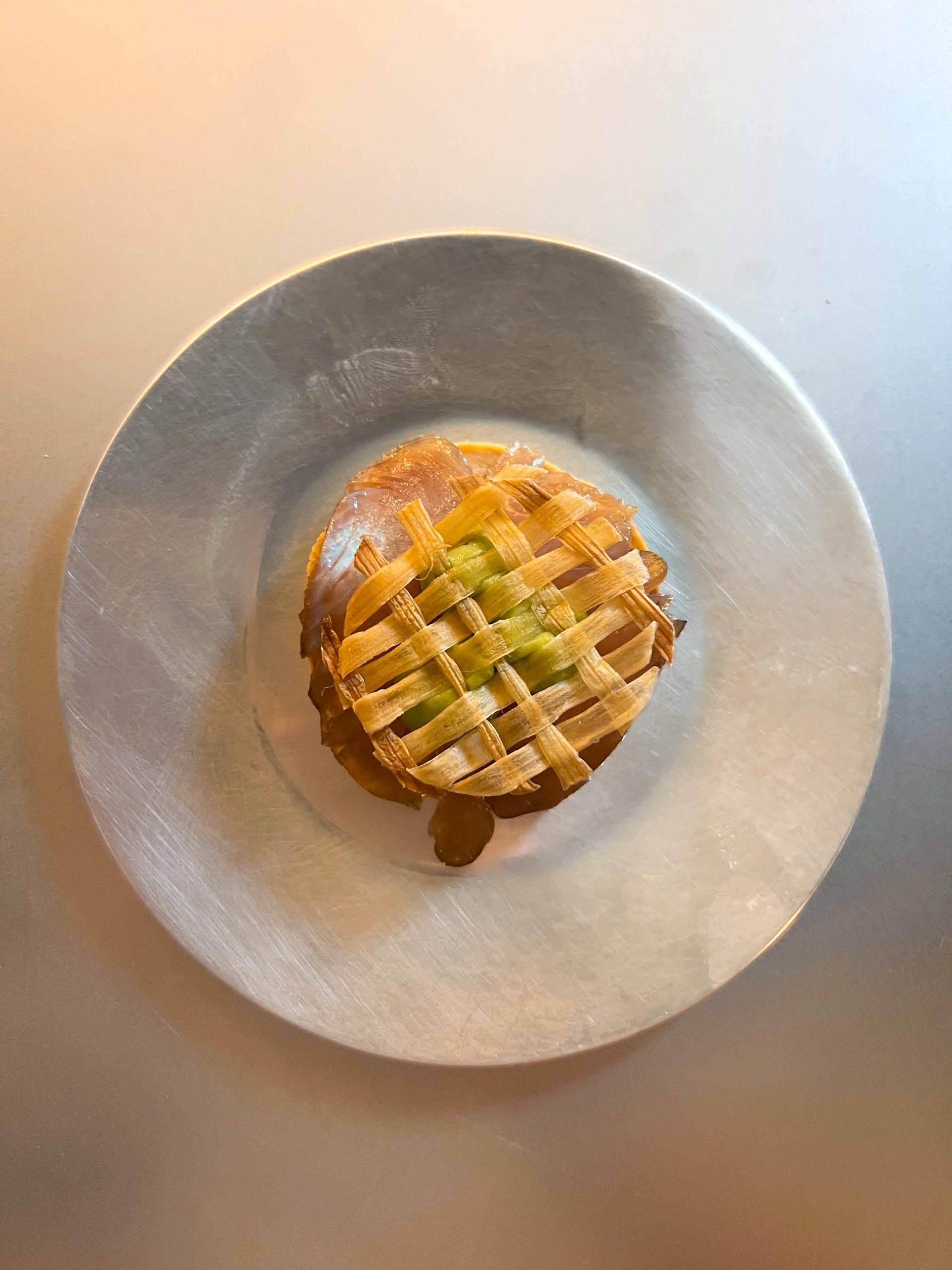 A pie on a white plate on a table.