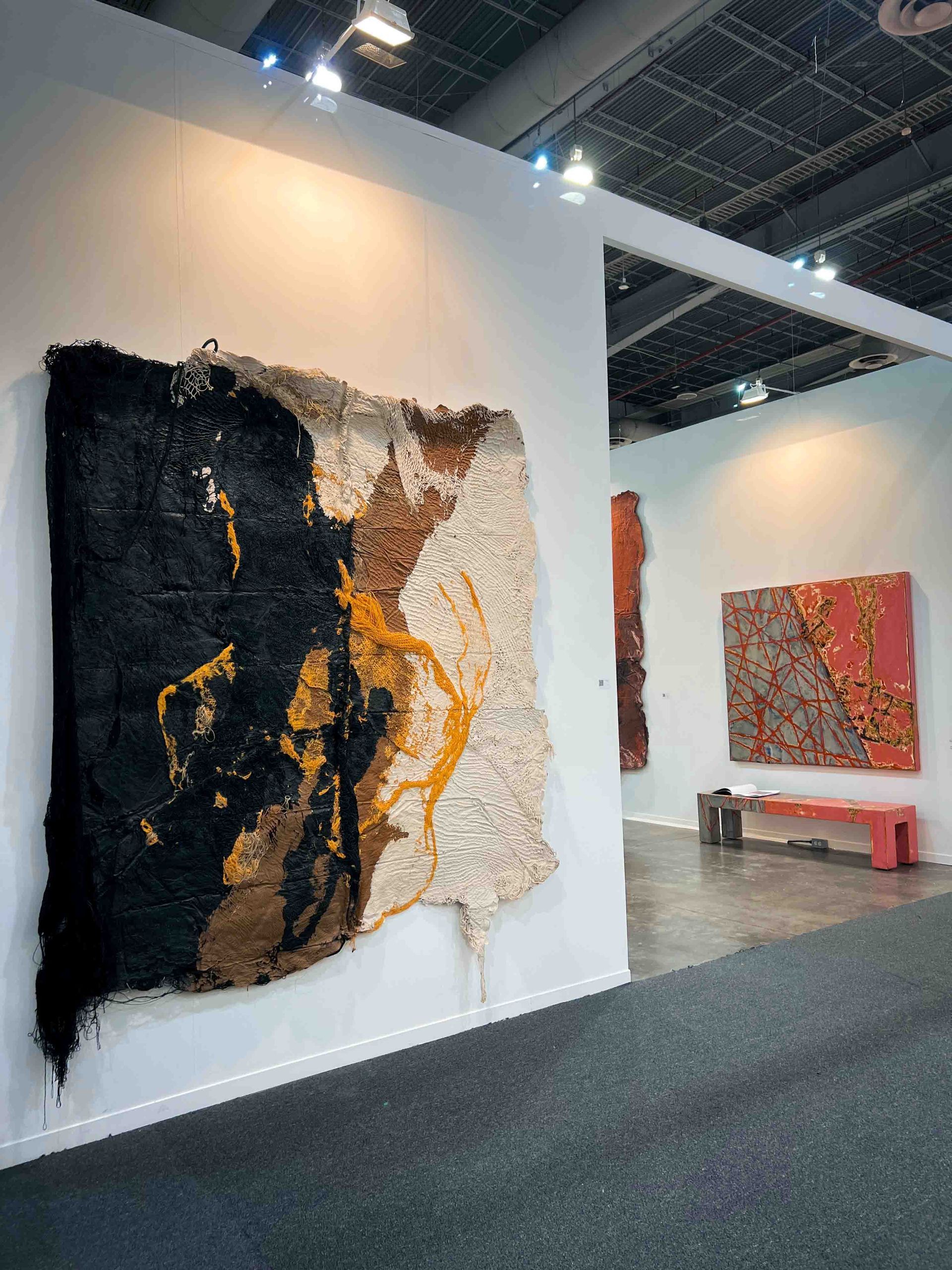 A large painting is hanging on a wall in a exhibition room in Mexico City during Art Week