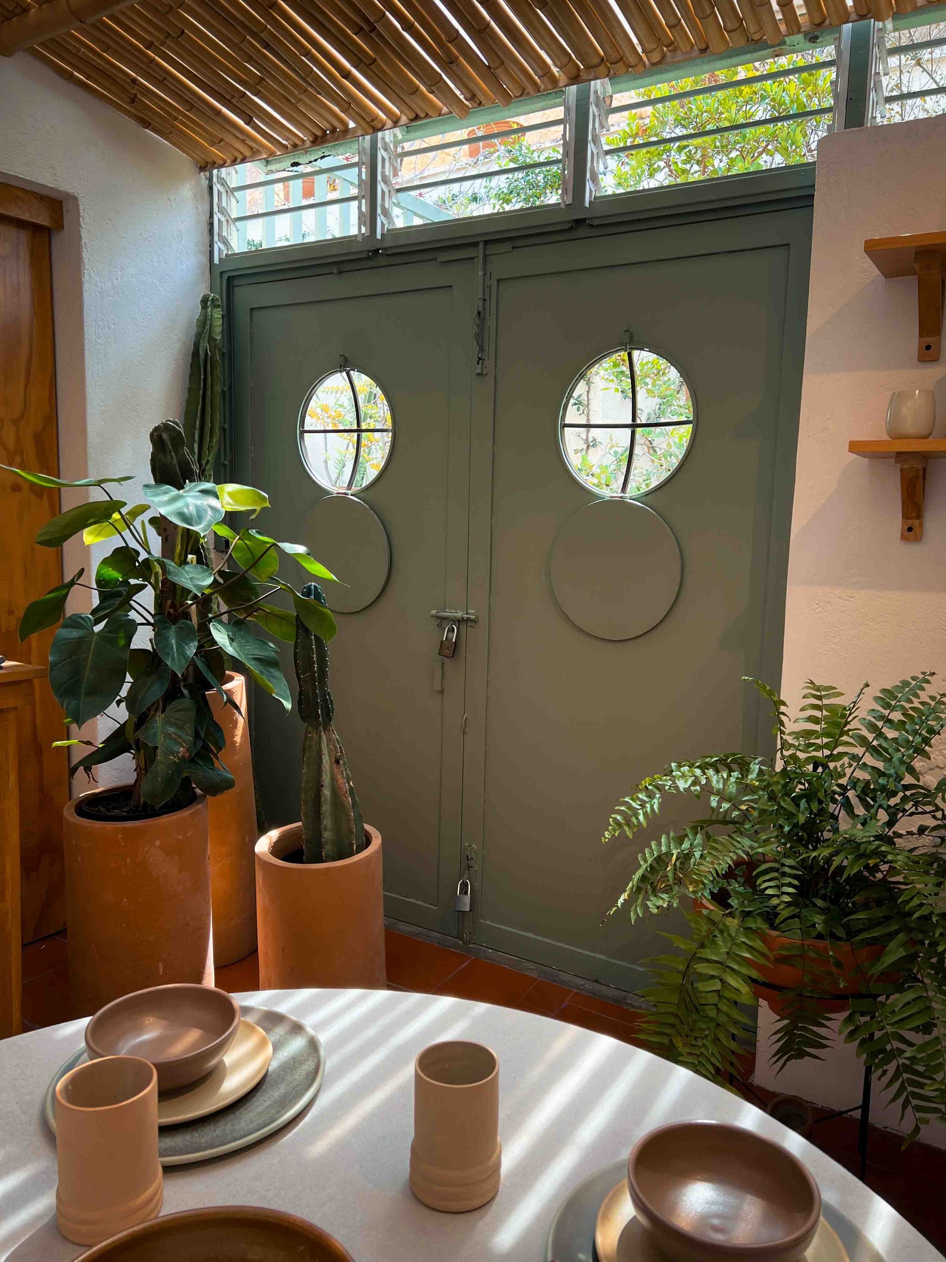 A table with bowls and plates on it in front of a green door.