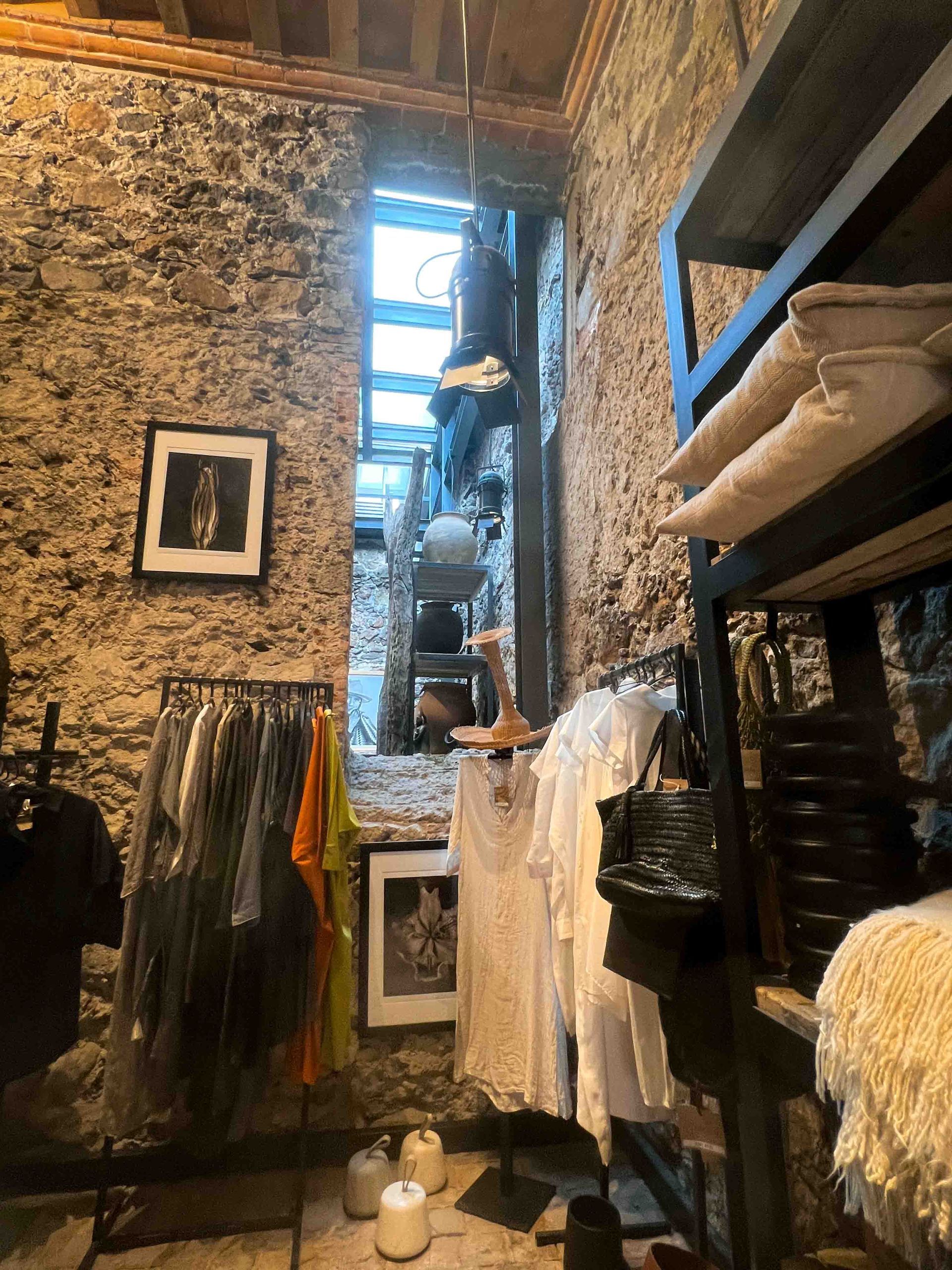 A room with clothes hanging on racks and a picture on the wall.
