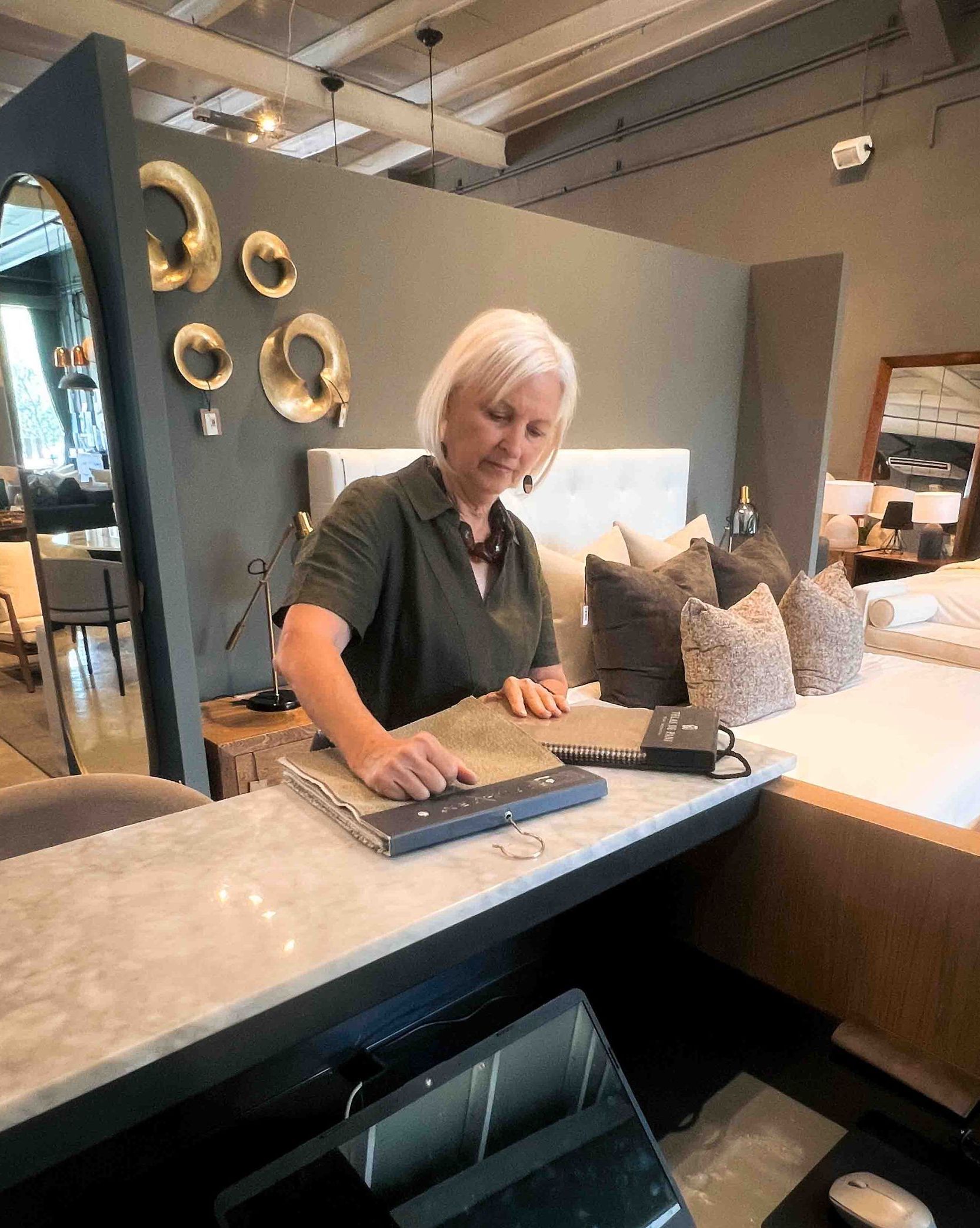 A woman is sitting at a counter in a store.