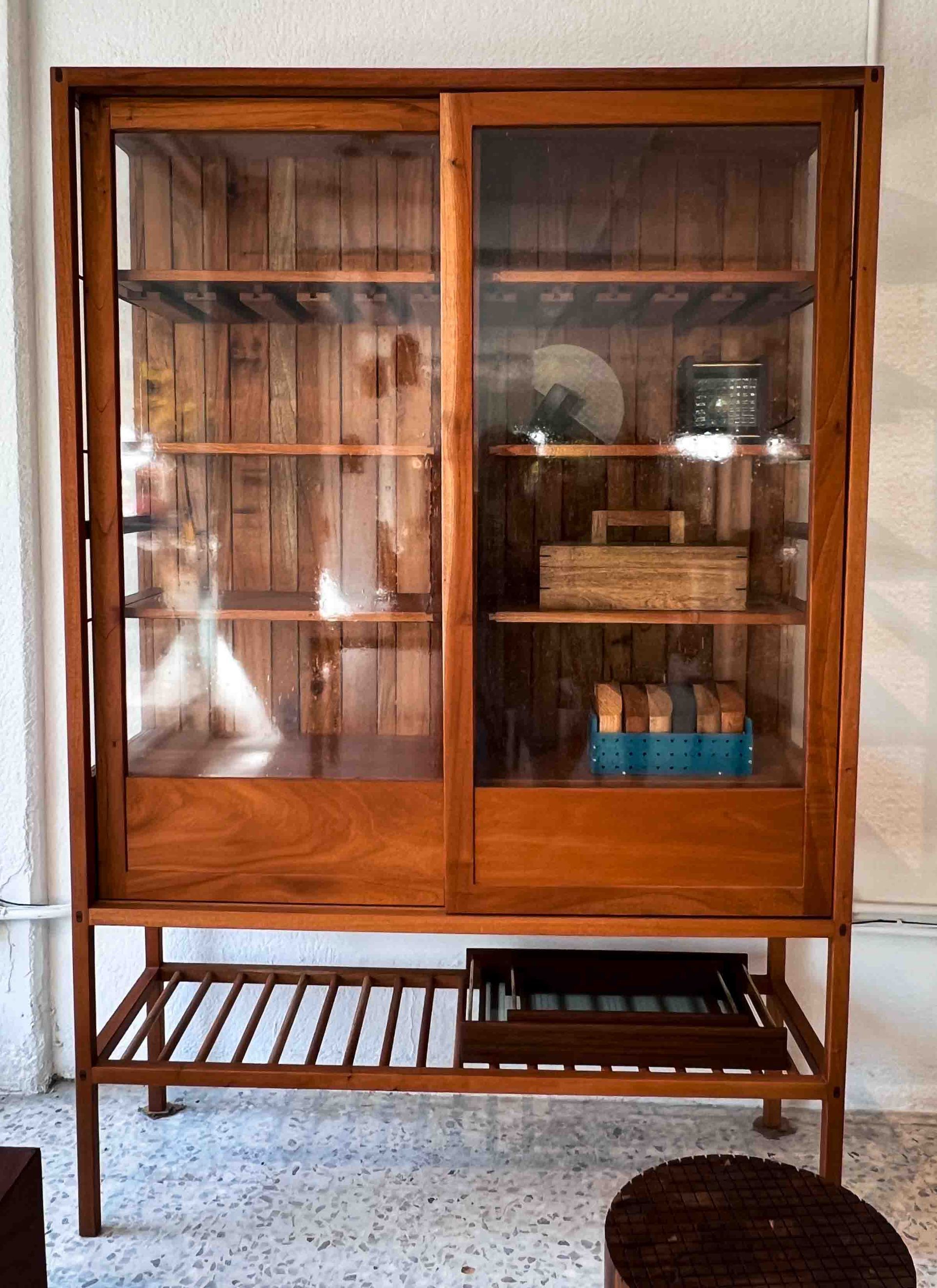 A large wooden cabinet with glass doors and shelves