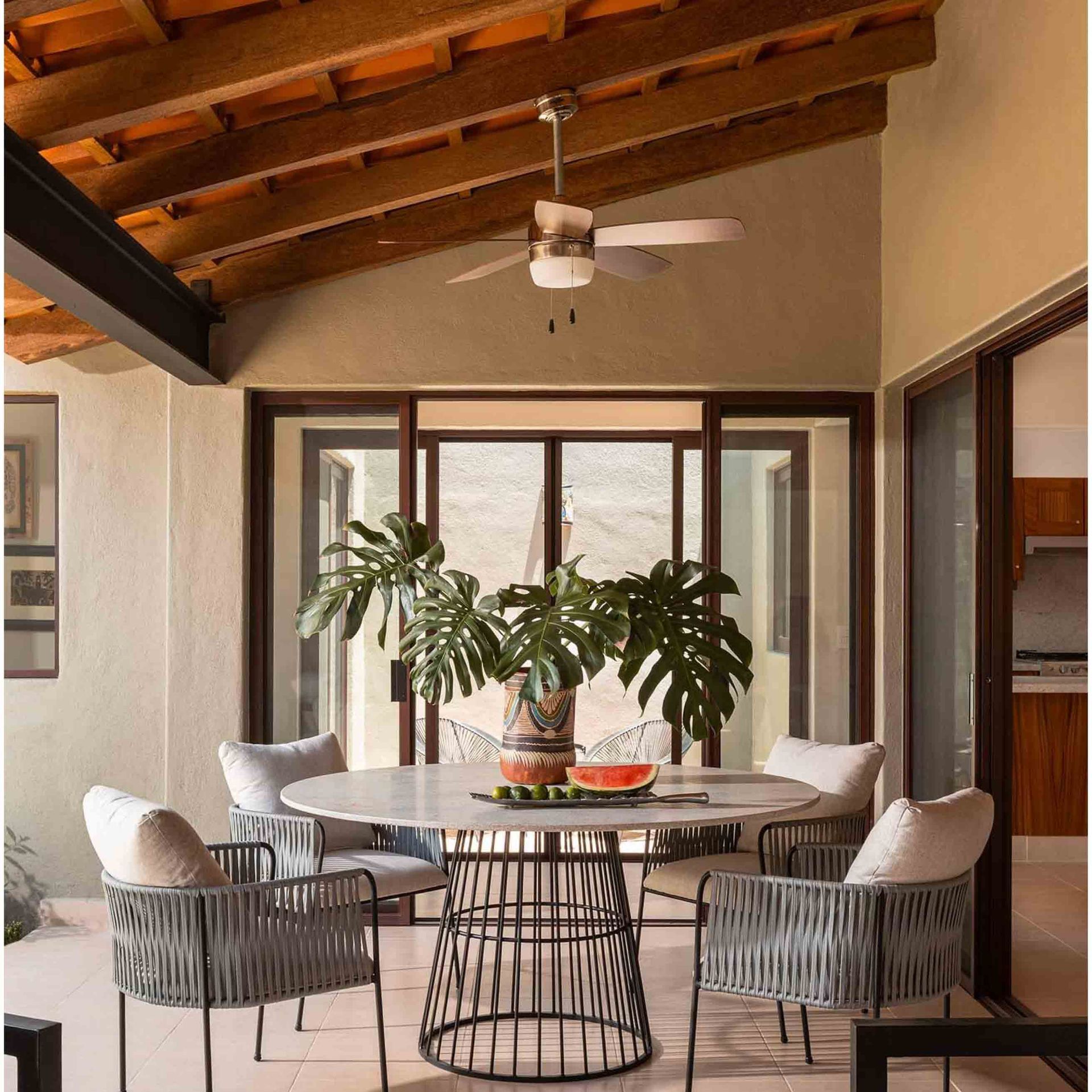 A dining room with a table and chairs and a ceiling fan