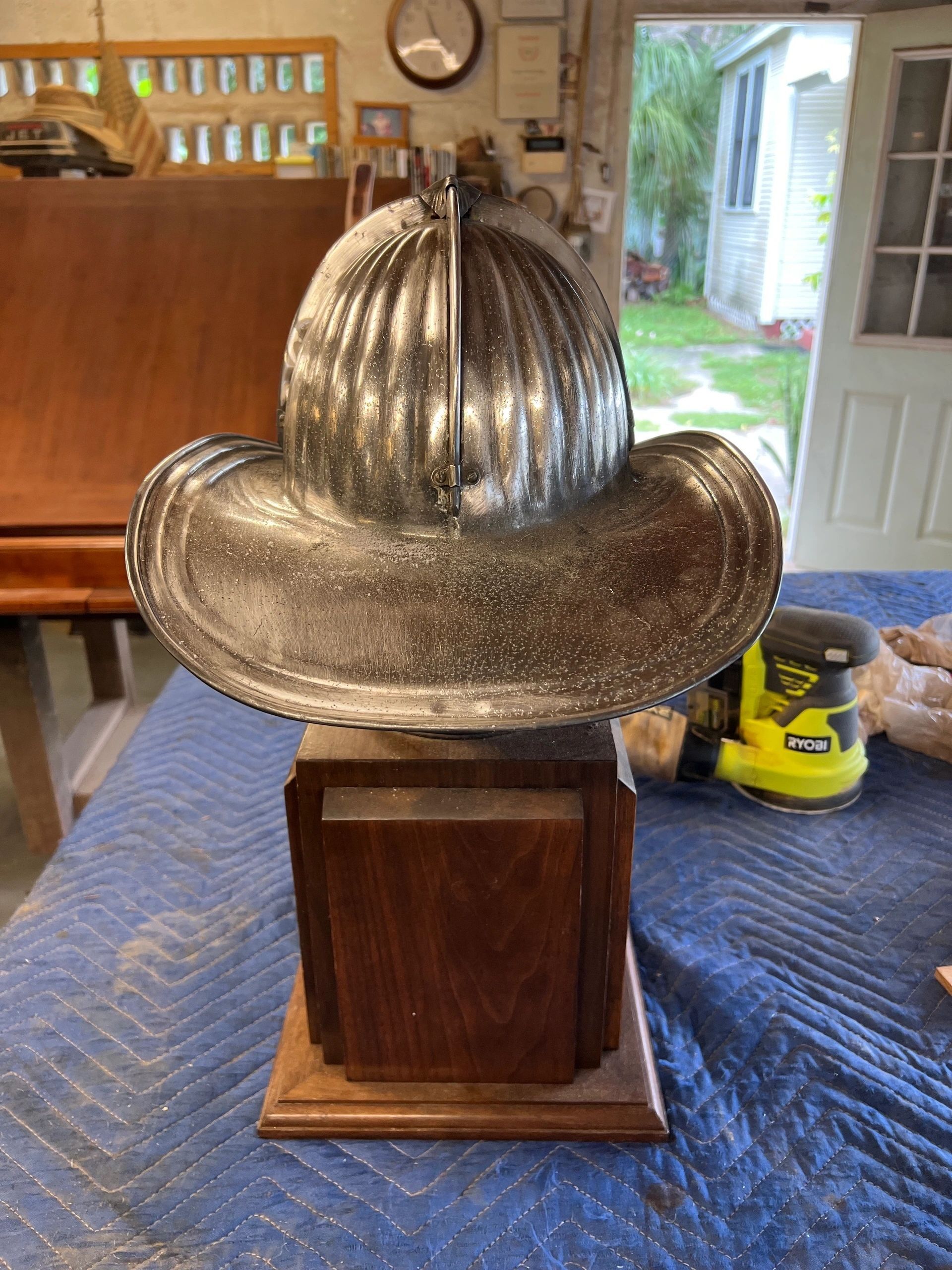 Firefighter helmet trophy on a wooden base in a workshop.