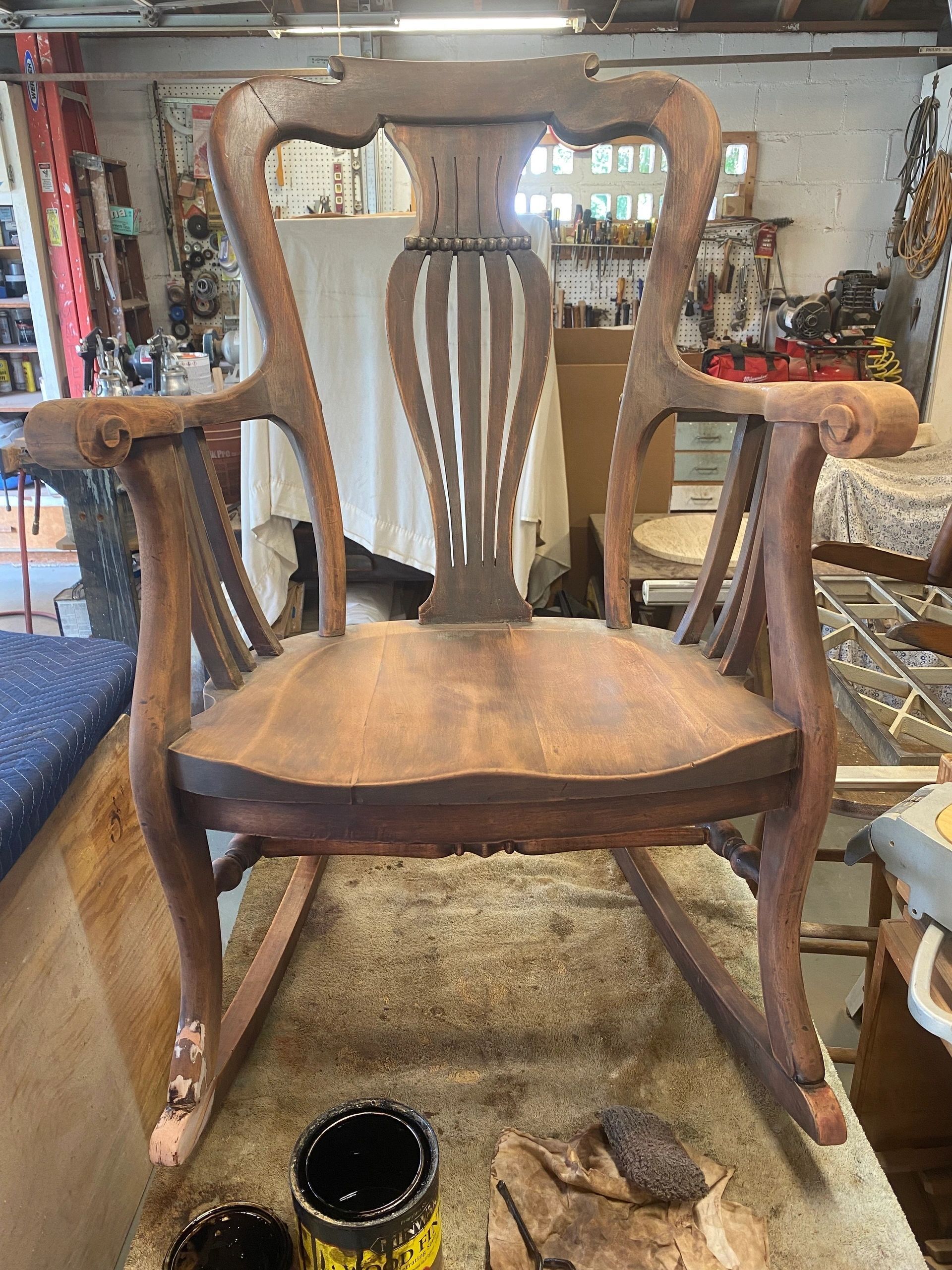 Wooden antique rocking chair, brown stained, in workshop.