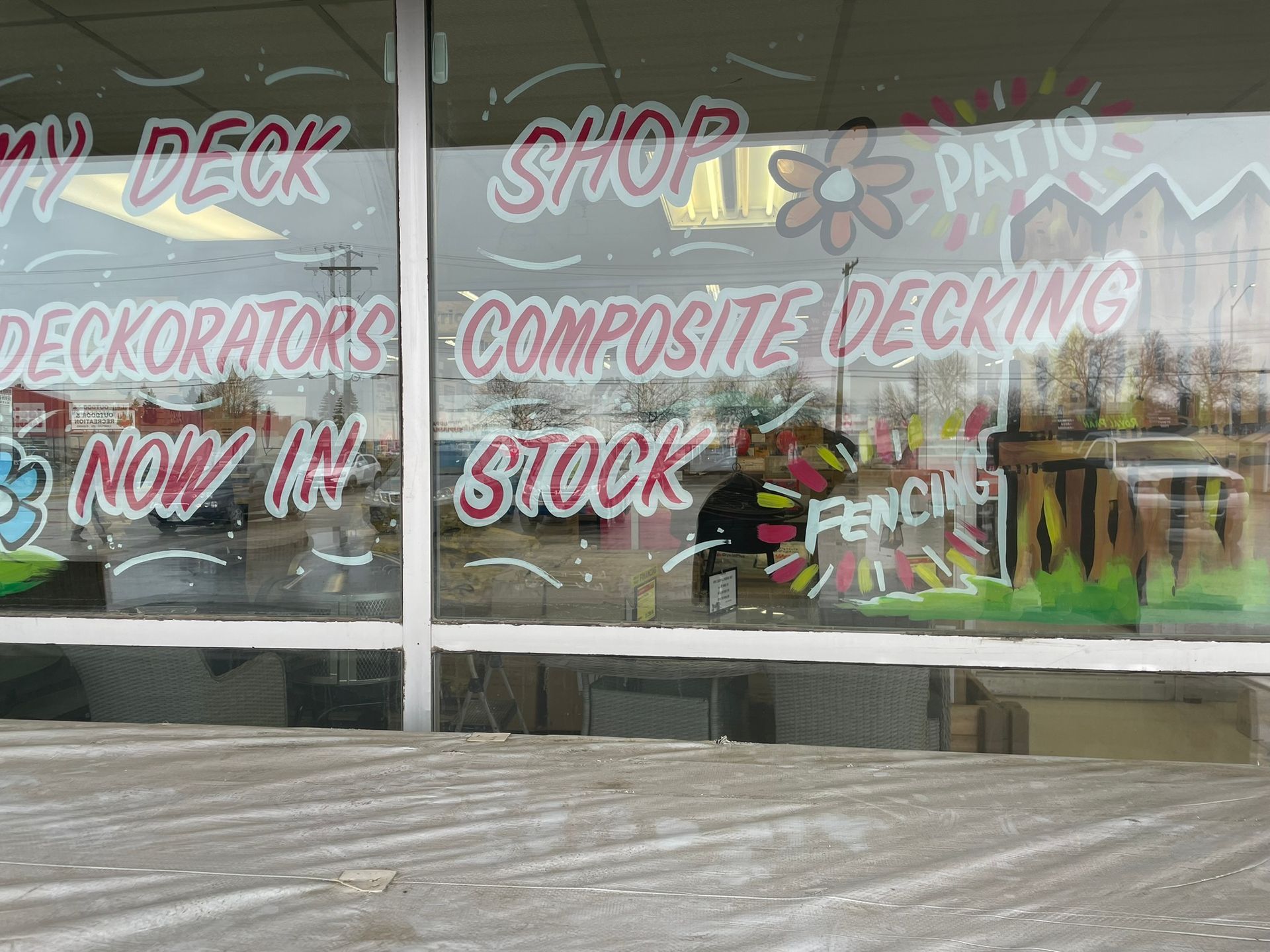 A window that says my deck shop decorators composite decking now in stock
