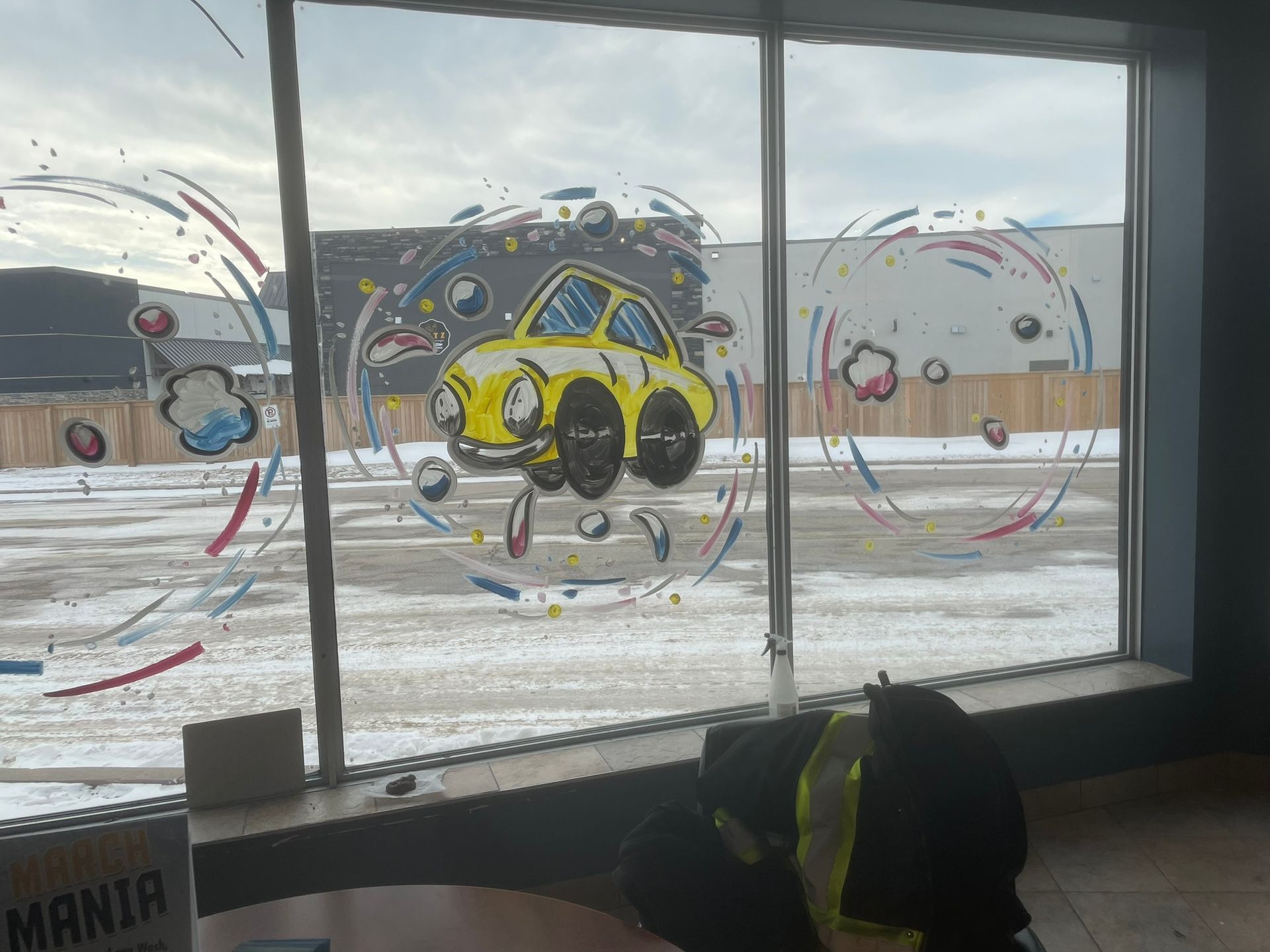 A window with a drawing of a yellow car on it.