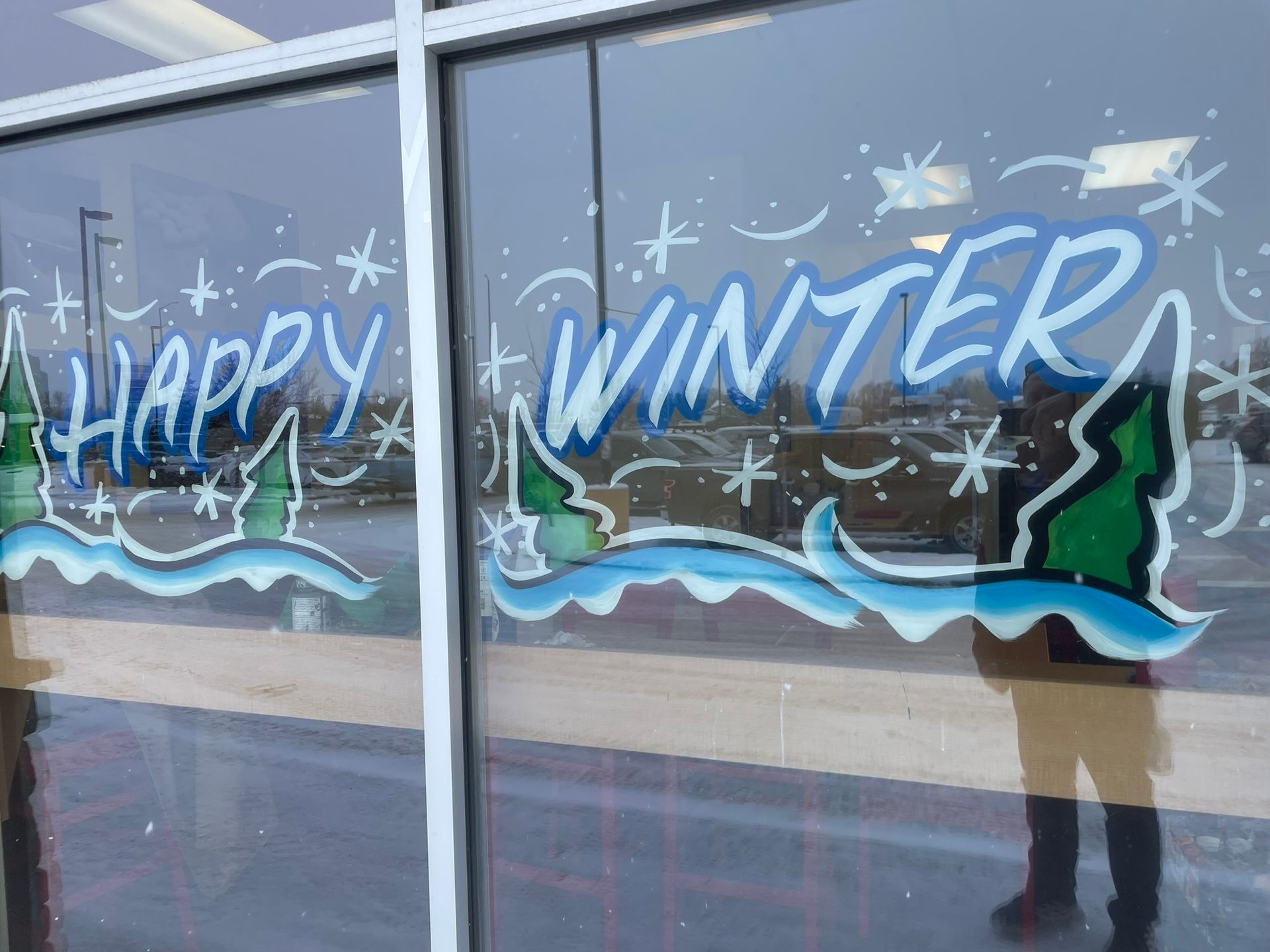 A window with the words `` happy winter '' painted on it.