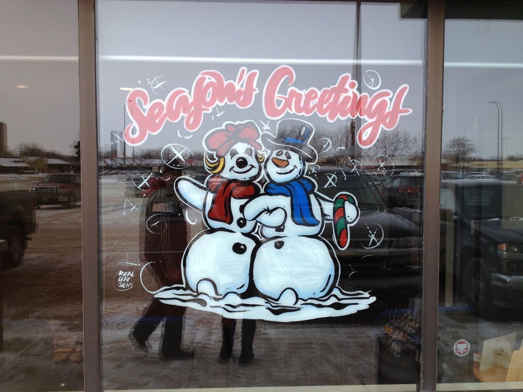 A window with two snowmen and the words 