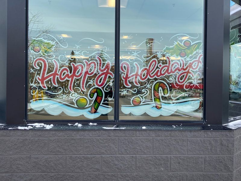 A window with the words `` happy holidays '' painted on it