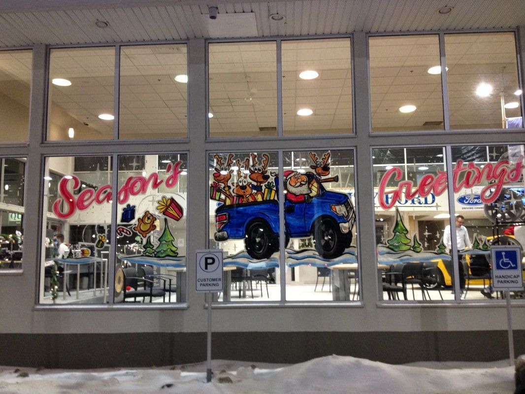 A car dealership has a christmas display in the windows