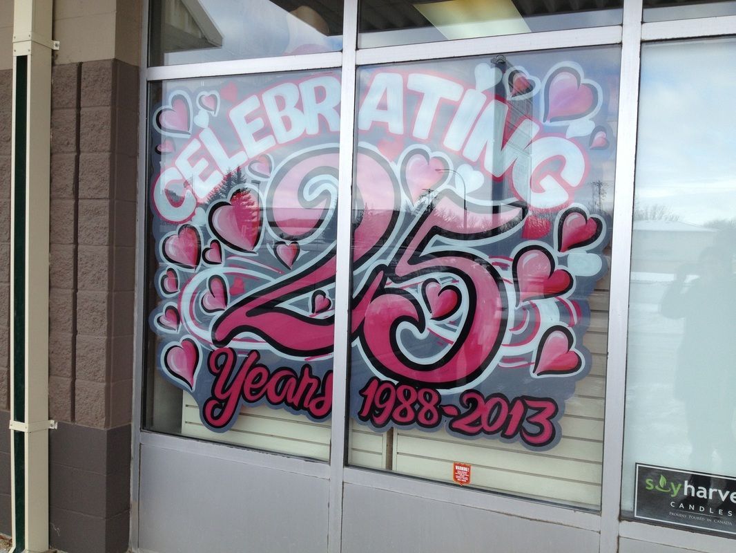 A window with graffiti on it that says celebrating 25 years 1988-2013