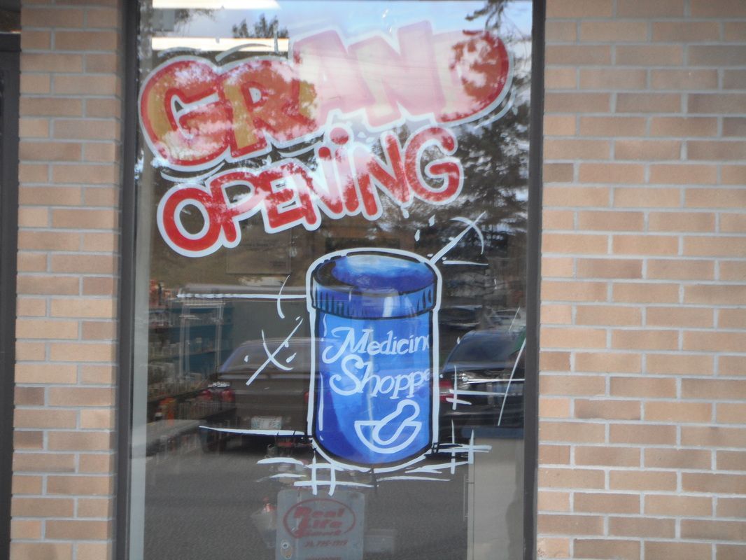 A window with a picture of a soda can and the words grand opening written on it