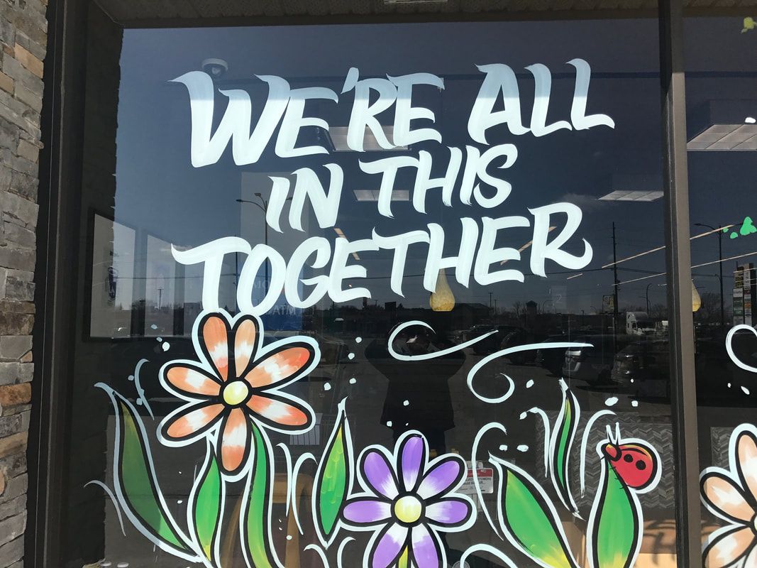 A sign on a window that says we 're all in this together