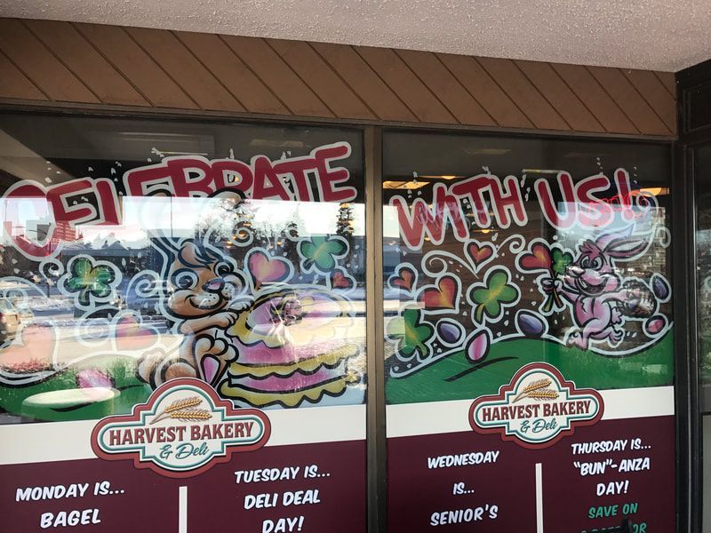 A harvest bakery window with a sign that says celebrate with us