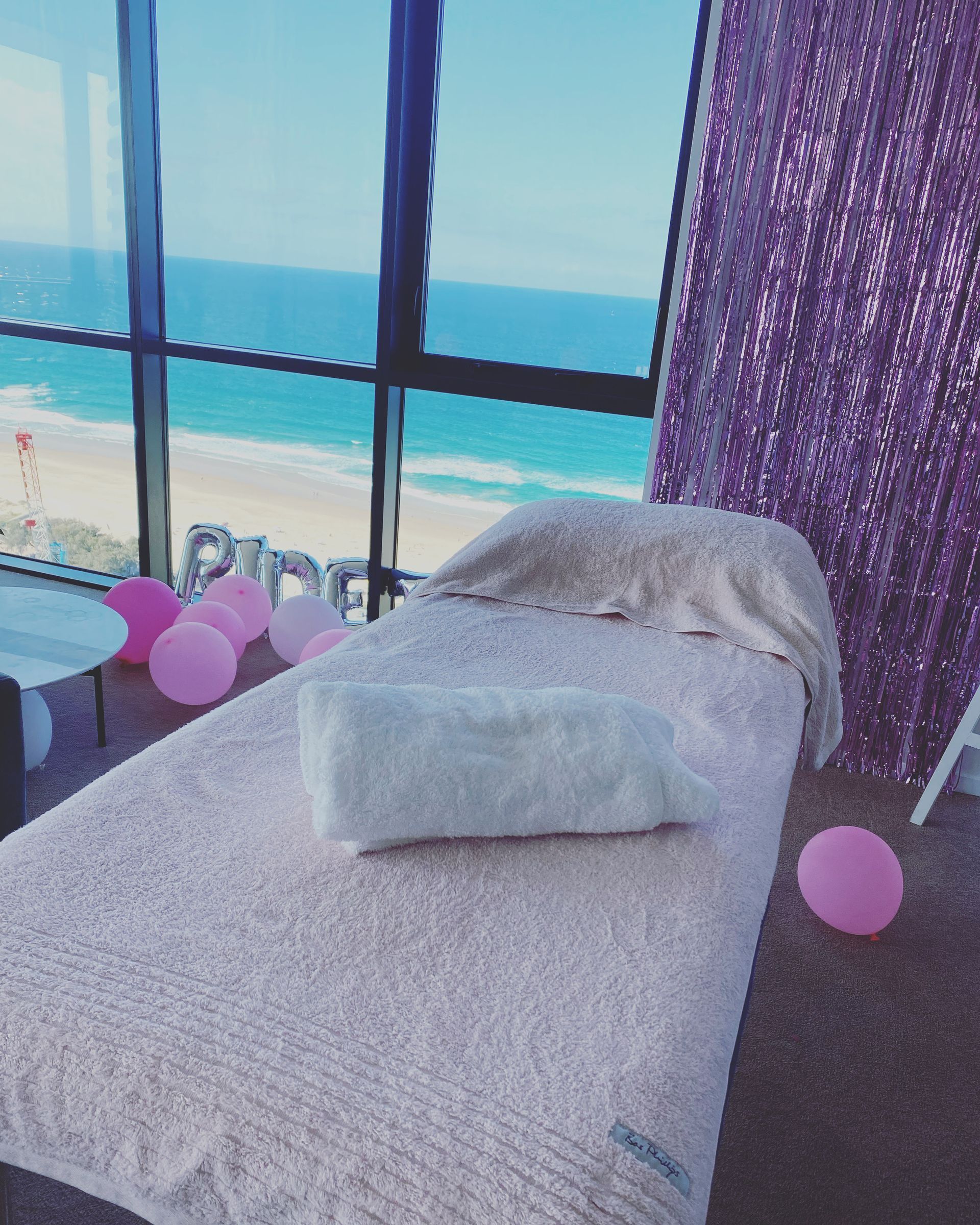 Massage Table Set up Near a Window Overlooking a Beach — Soul Good Beauty in Miami, QLD