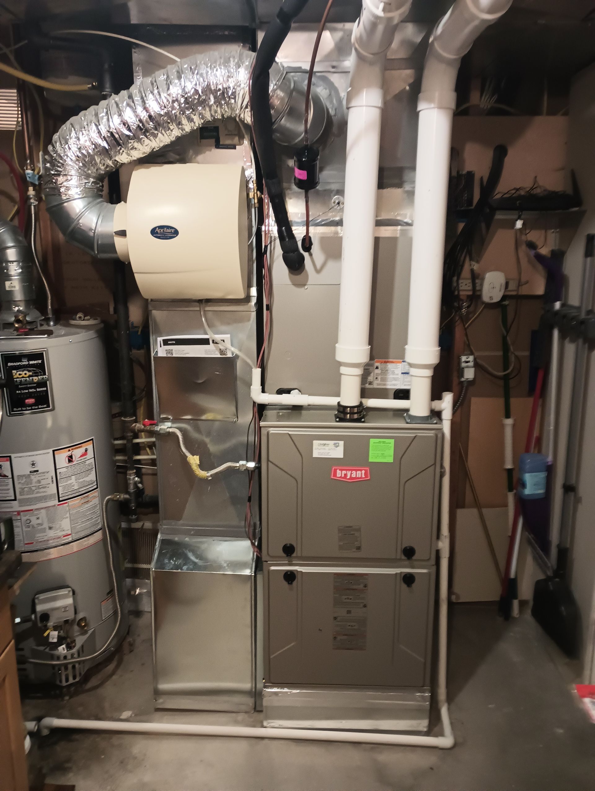 Utility room with furnace, ducts, pipes, and mechanical equipment in a basement area