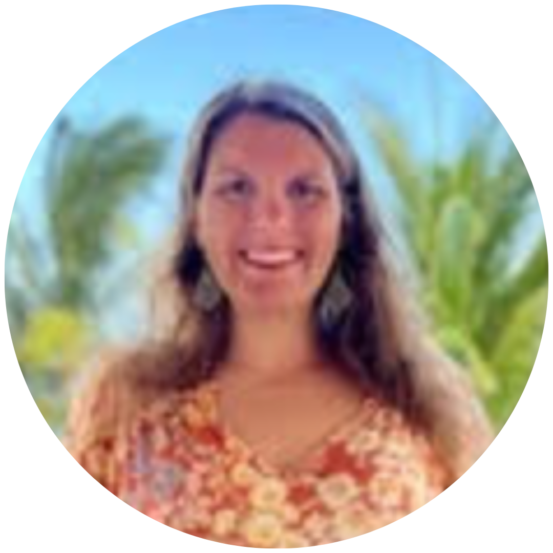 A smiling person with long hair wearing a patterned top in front of a blurred tropical background of palm trees.