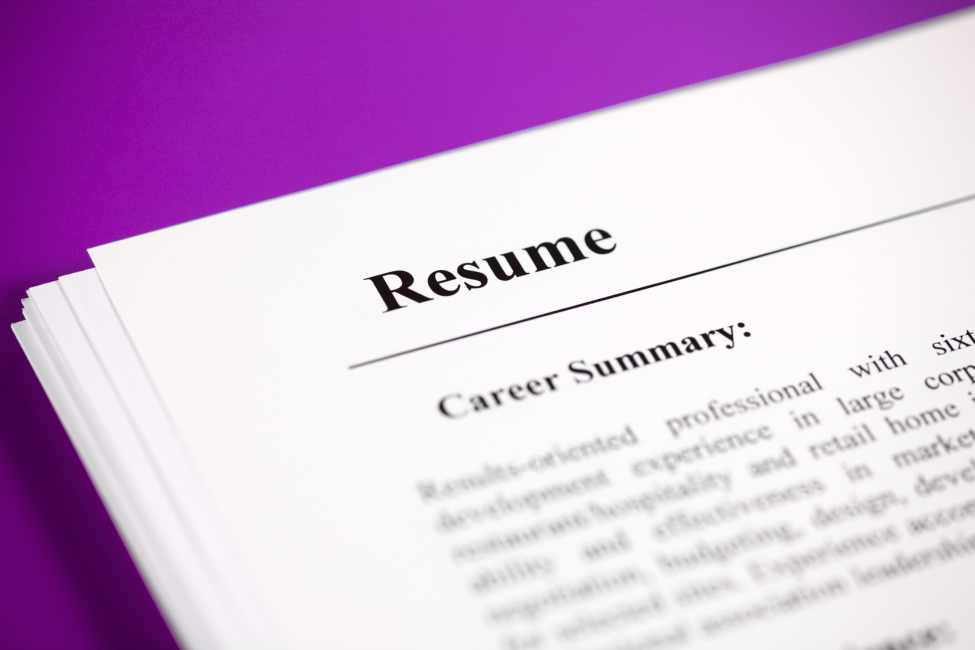 Stack of resumes on a purple background, with the top page titled “Resume” and “Career Summary.”