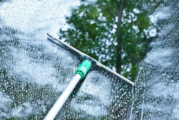 A Window brush cleaning the soapsuds off a window — Active Cleaning Service Maitland, NSW