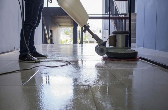 A person cleaning tiles with a machine — Active Cleaning Service Maitland, NSW