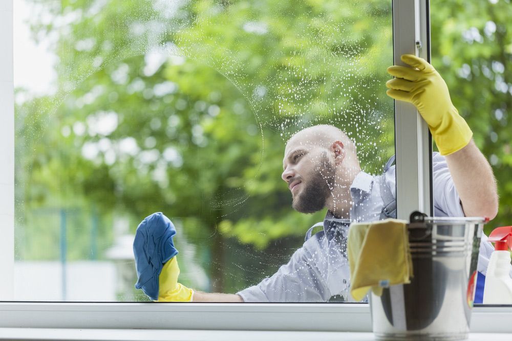 Man Professionally Cleaning a Window