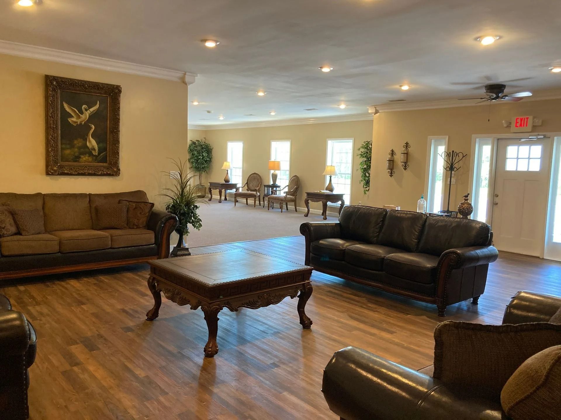 Spacious lobby with sofas, coffee table, hardwood floors, and warm ceiling lights