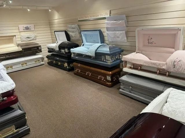 Mattresses and bed frames displayed in a showroom with beige carpet and light walls