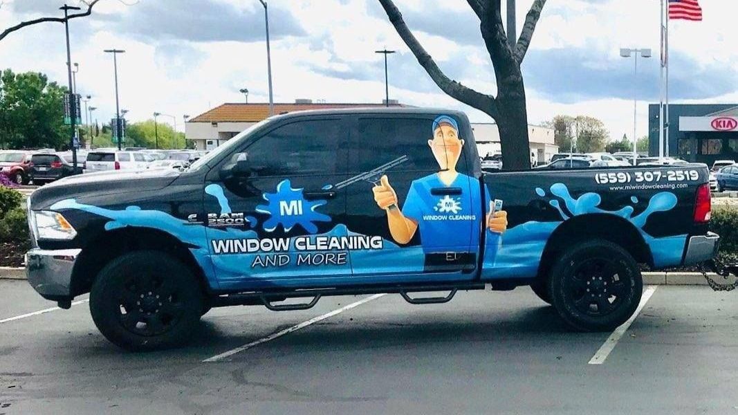 A window cleaning truck is parked in a parking lot