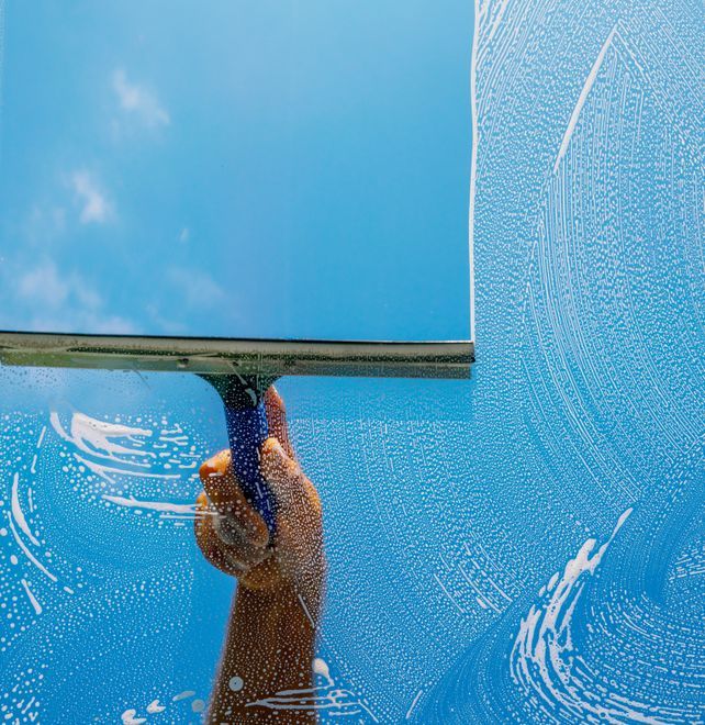 a person is cleaning a window with a squeegee .