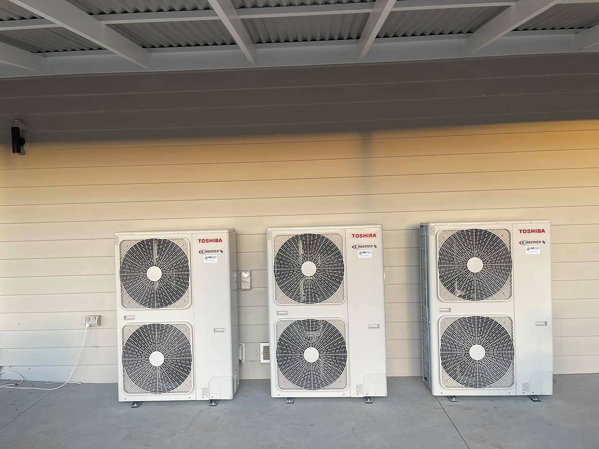 Three Air Conditioners Are Lined Up On The Side Of A Building — Aircon Mid North Coast in Port Stephens, NSW