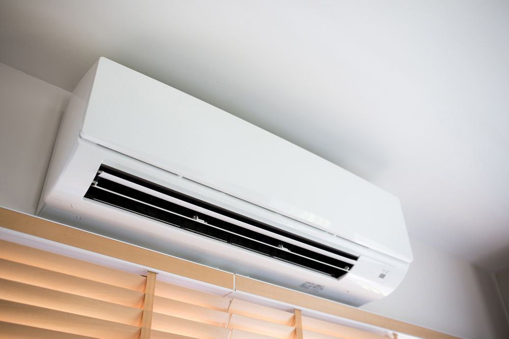 A White Air Conditioner Is Hanging From The Ceiling In A Room — Aircon Mid North Coast in Gloucester, NSW