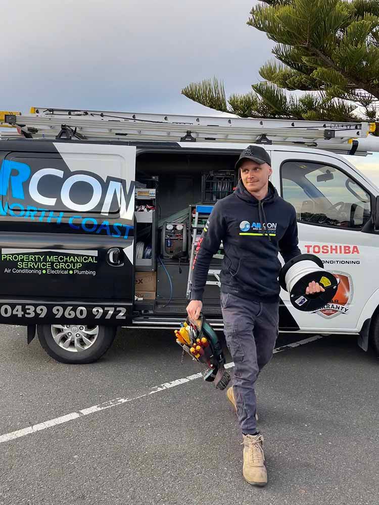 Technician Walking while Holding Electrical Tools — Aircon Mid North Coast in Wingham, NSW