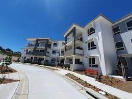 A Large Apartment Building With A Concrete Walkway Leading To It — Aircon Mid North Coast in Forster, NSW