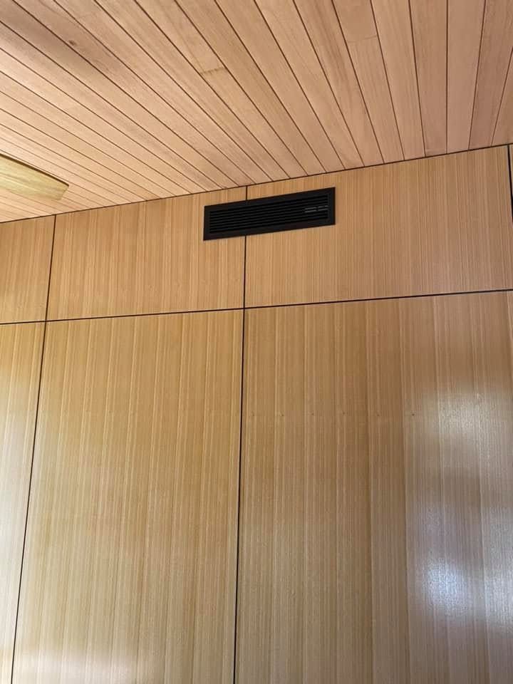 Black Ducted Air Conditioner Installed in A Wooden Wall