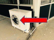 White air conditioner with red arrow pointing to it — Air Conditioning Electricians in Forster NSW