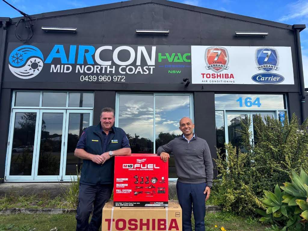 Two Men Standing in Front of An Air Conditioner Shop