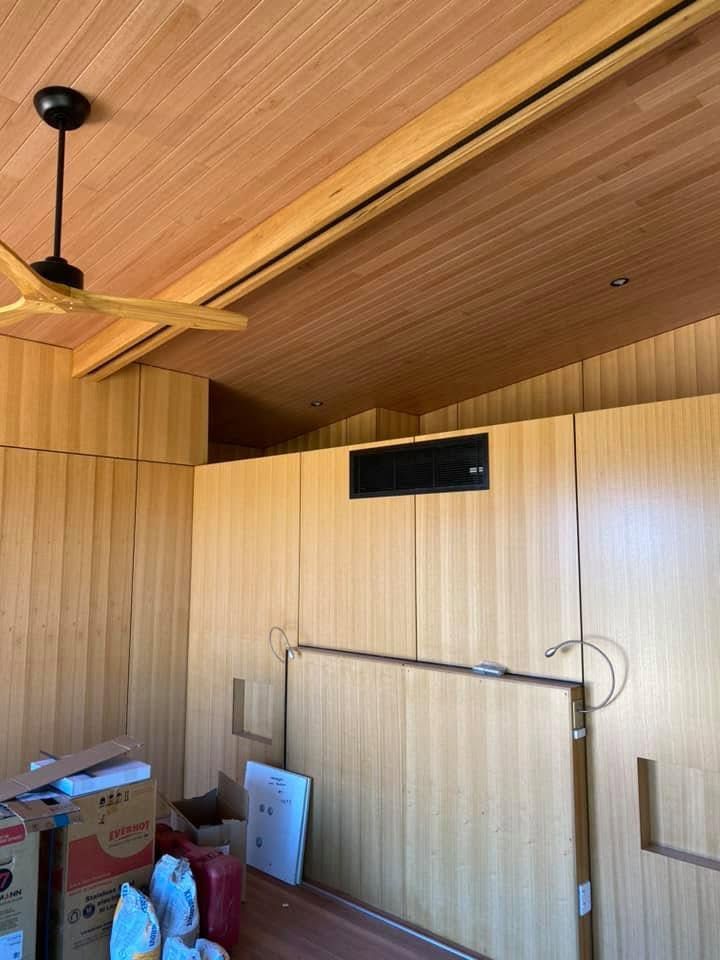 Wooden-Themed Room with Black Ducted Air Conditioner on Wall