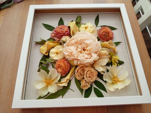 Bouquet of cream roses with greenery on a white textured cloth