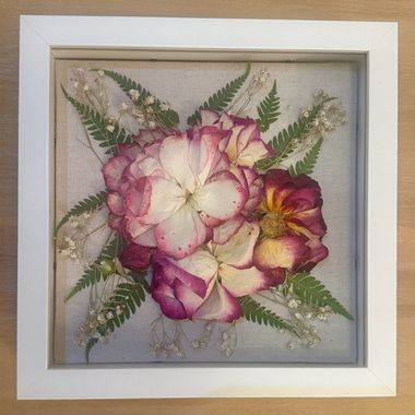 Framed floral artwork with pink, white, and yellow flowers and green fern leaves on a light background