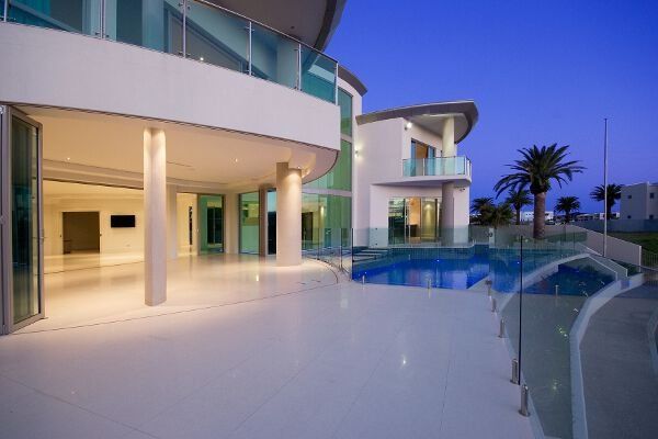 Modern luxury house patio with curved pool at dusk